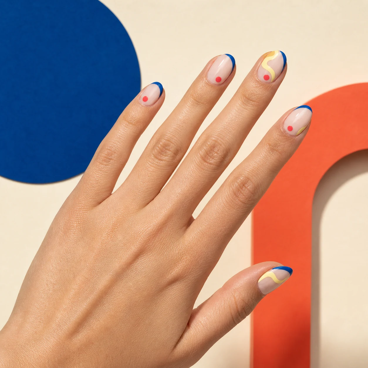 Graphic nude manicure with blue tips and colorful details
